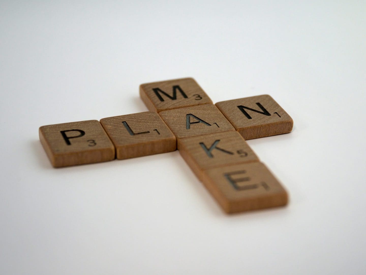 una cruz de madera arañada con la palabra plan deletreada en ella